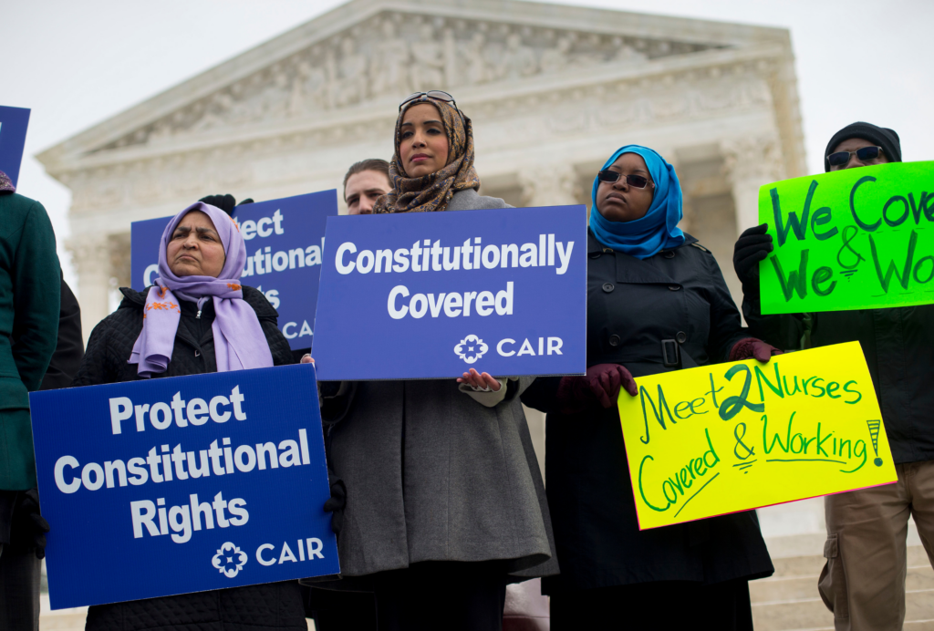 crowd of protestors with signs saying "protect constitutional rights"