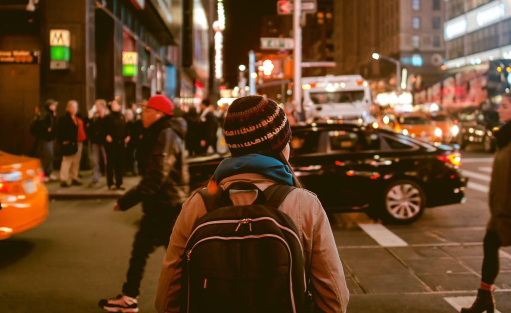 Image of the back of a woman walking down a busy city street