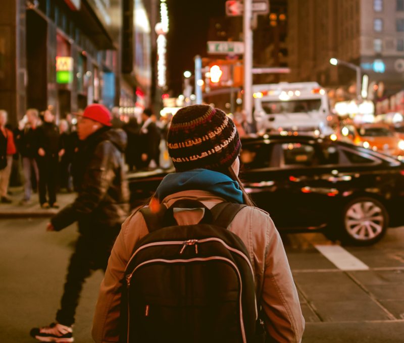 Image of the back of a woman walking down a busy city street